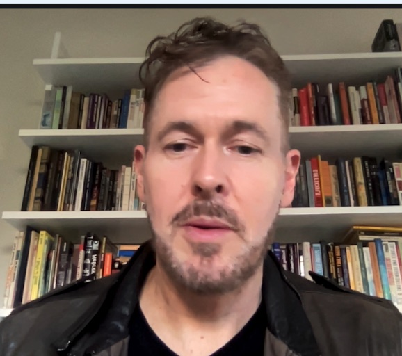 Dario Nardi in front of bookshelves